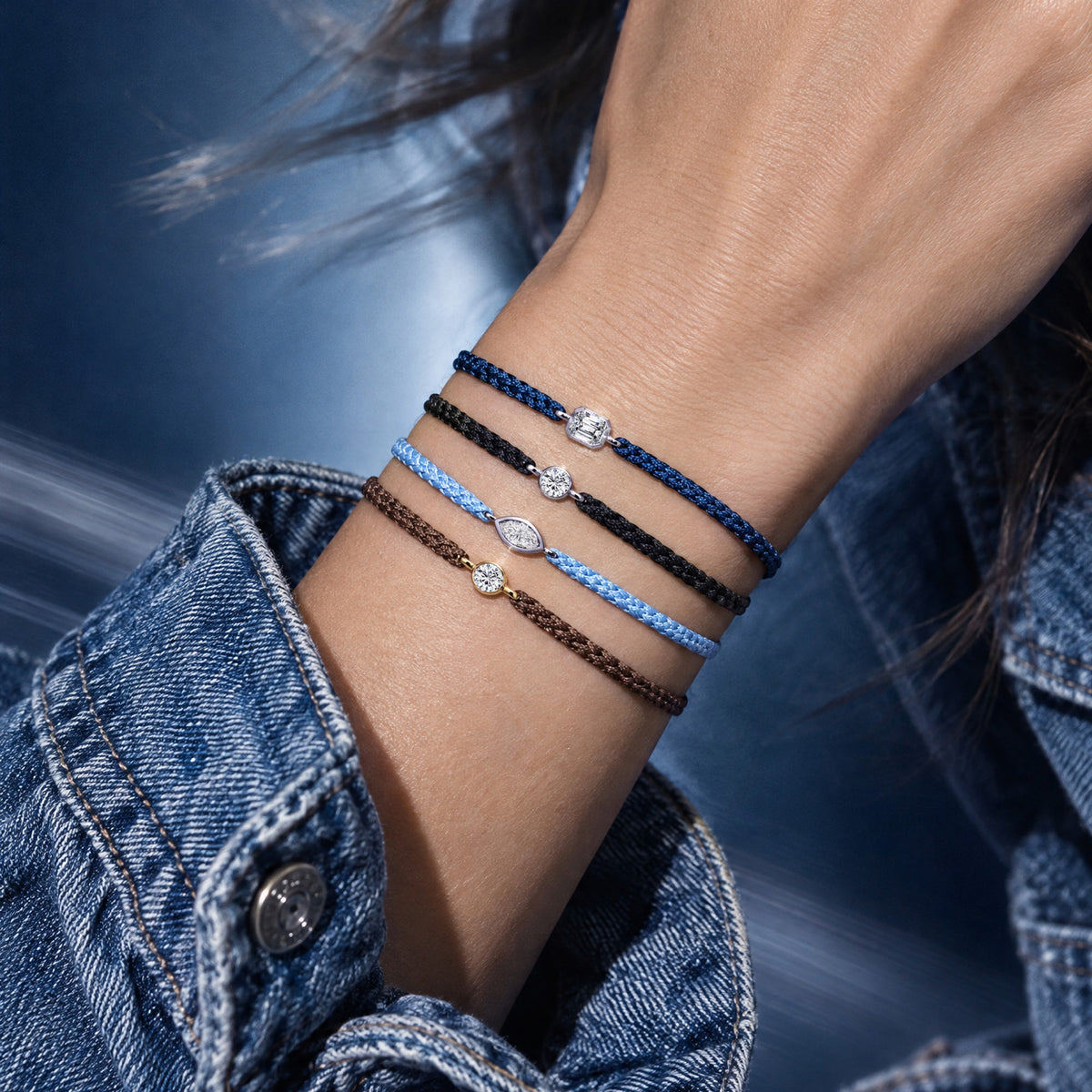Frau trägt mehrere DIAMONET Textilarmbänder mit 0.20 ct Lab Grown Diamonds in verschiedenen Farben und Diamantschliffen