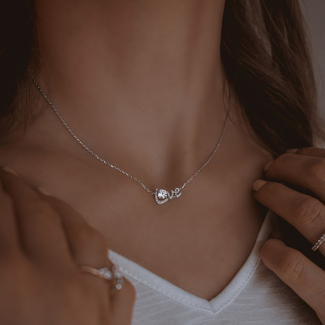 Frau trägt ein feines Collier mit Diamanten als eleganten Halsschmuck
