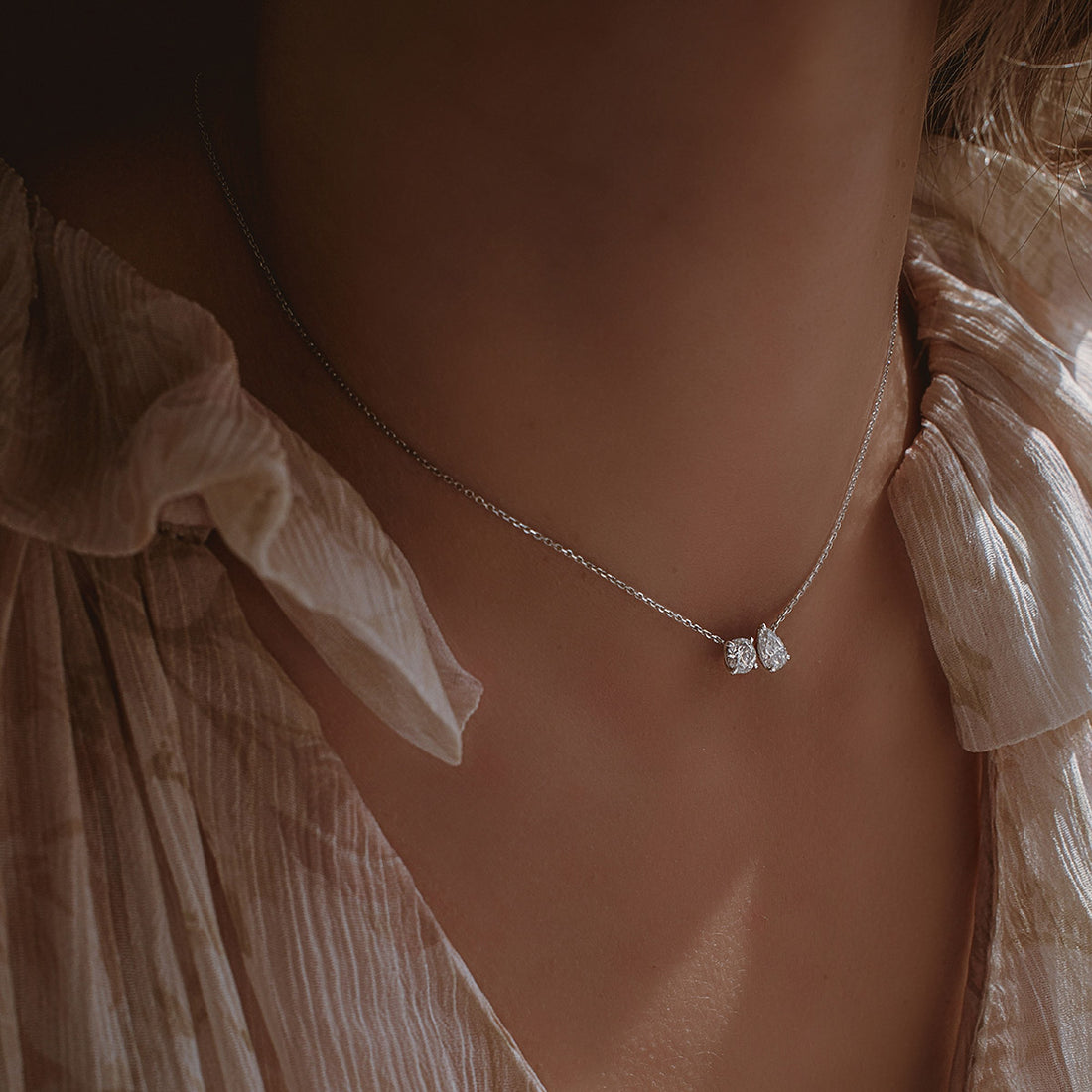 Feines Collier mit einzeln gefasstem Diamanten am Hals einer Frau